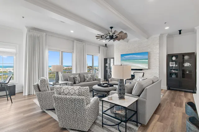 a living room with furniture kitchen view and a chandelier