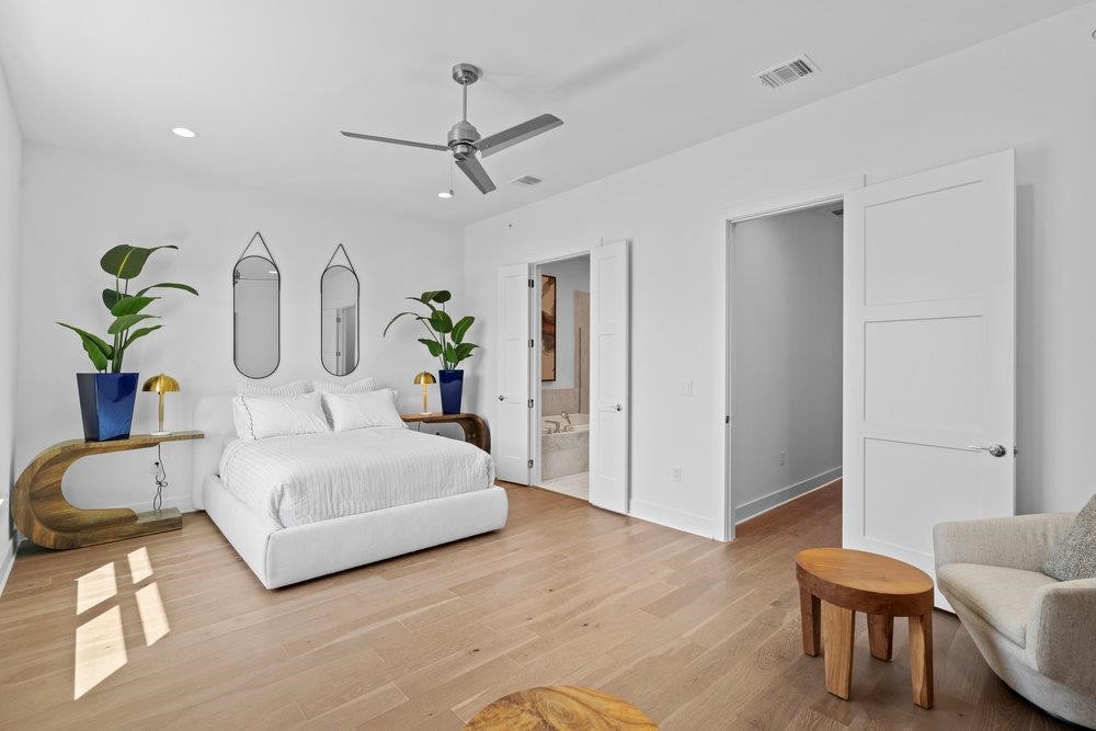 2805 McCurdy Street, Unit 7 Austin, TX 78723 - Photo 15 of 40 a spacious bedroom with a bed a chandelier and a couch