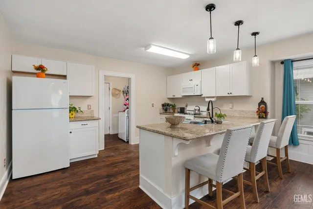 a kitchen with white cabinets and white appliances