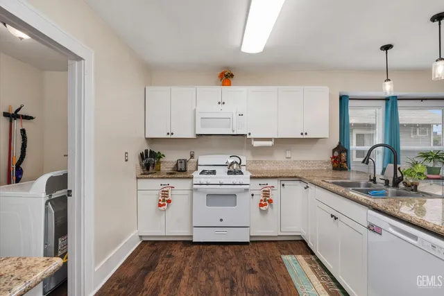 a kitchen with stainless steel appliances granite countertop a stove and white cabinets