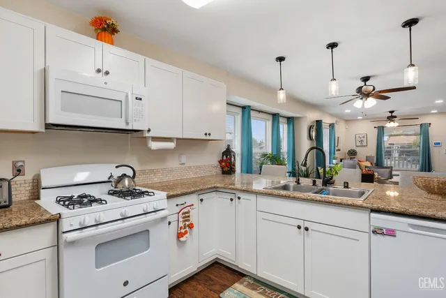 a kitchen with white cabinets and white appliances