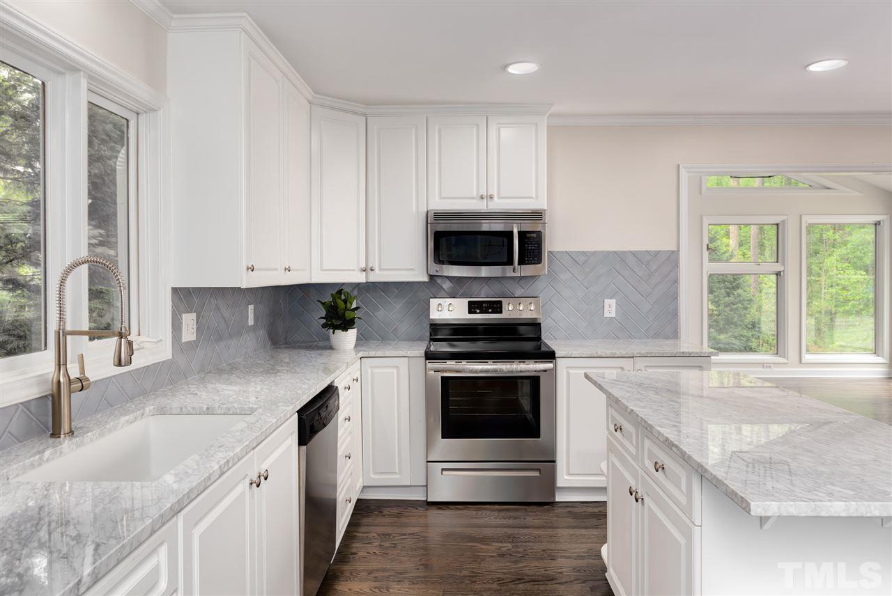 6820 Rainwater Road Raleigh, NC 27615 - Photo 14 of 22 a kitchen with stainless steel appliances granite countertop a sink stove and microwave