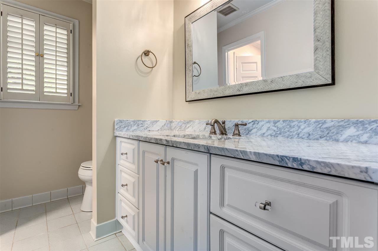 6820 Rainwater Road Raleigh, NC 27615 - Photo 20 of 22 a bathroom with a granite countertop toilet sink and mirror