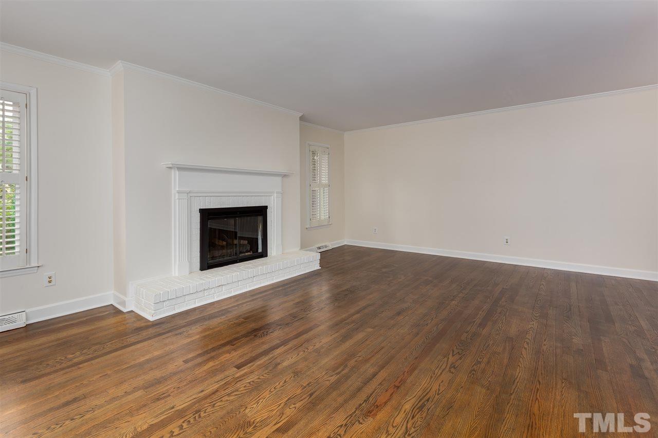 6820 Rainwater Road Raleigh, NC 27615 - Photo 8 of 22 a view of an empty room with wooden floor fireplace and a window