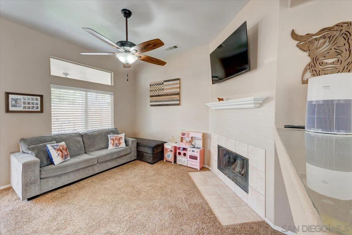 1359 H Street Ramona, CA 92065 - Photo 14 of 52 a living room with furniture a flat screen tv and a fireplace