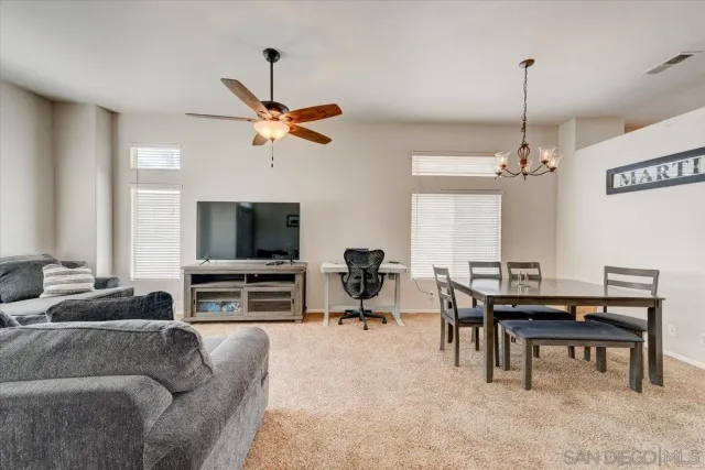 a living room with furniture a flat screen tv and a window