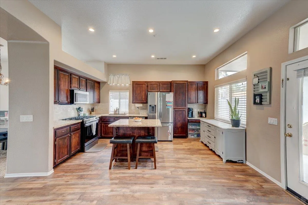 1359 H Street Ramona, CA 92065 - Photo 2 of 52 a kitchen with stainless steel appliances kitchen island granite countertop a refrigerator and a stove top oven