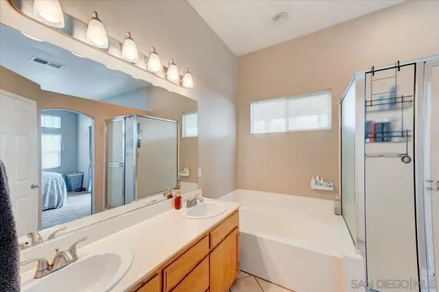 a bathroom with a tub a sink and a large mirror