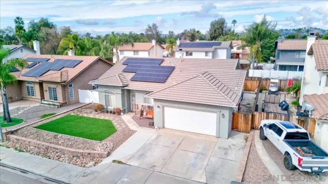 a front view of a house with a garden and parking