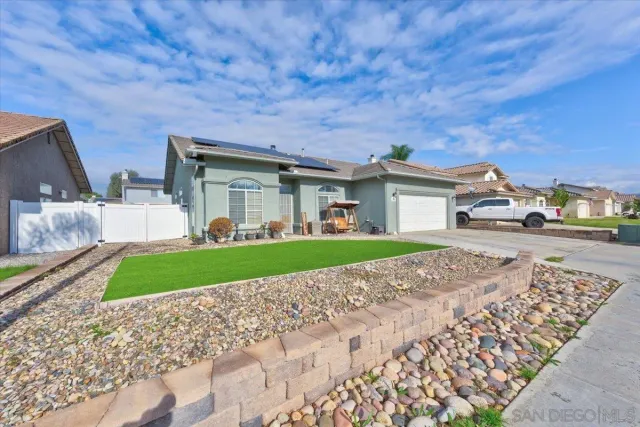 a view of a white house with a big yard and large tree