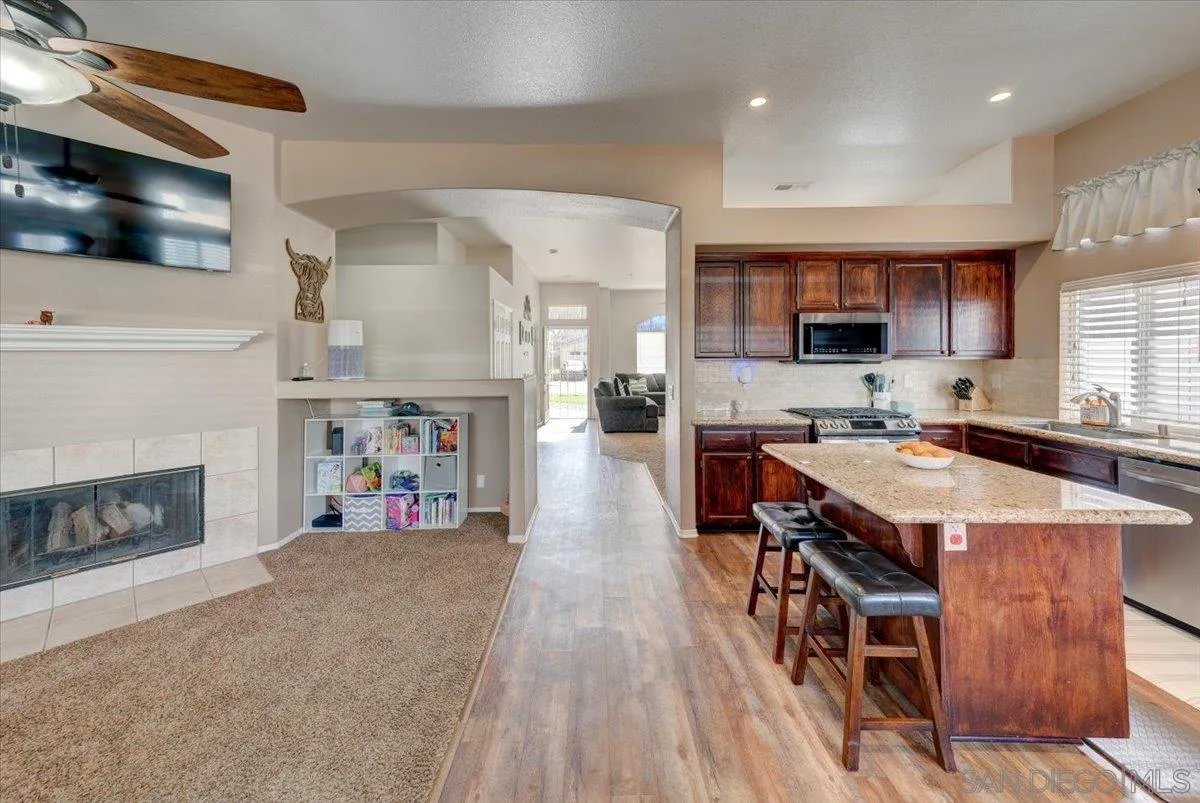 1359 H Street Ramona, CA 92065 - Photo 10 of 52 a living room with stainless steel appliances furniture a fireplace a flat screen tv and a fireplace