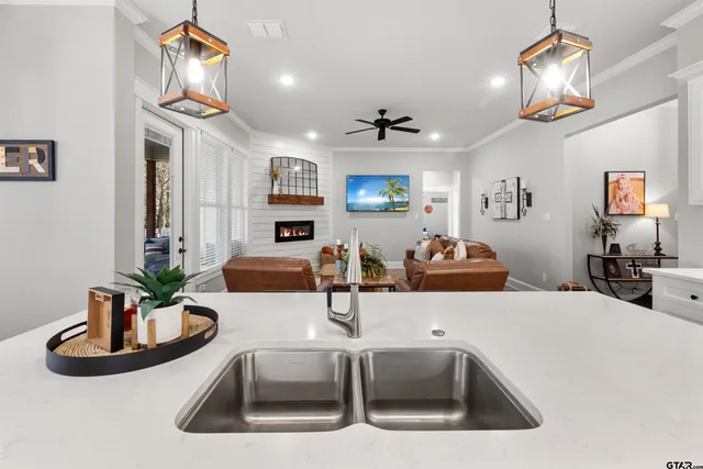 a kitchen with stainless steel appliances a sink a counter space and living room view