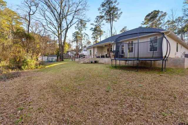 a view of a backyard with wooden fence and a bench
