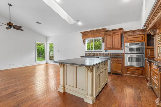 a kitchen with stainless steel appliances granite countertop a sink stove and wooden floor