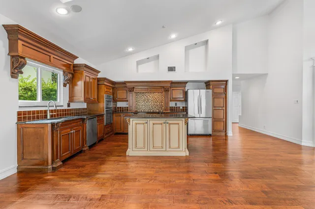 a kitchen with stainless steel appliances granite countertop a stove a sink and a refrigerator