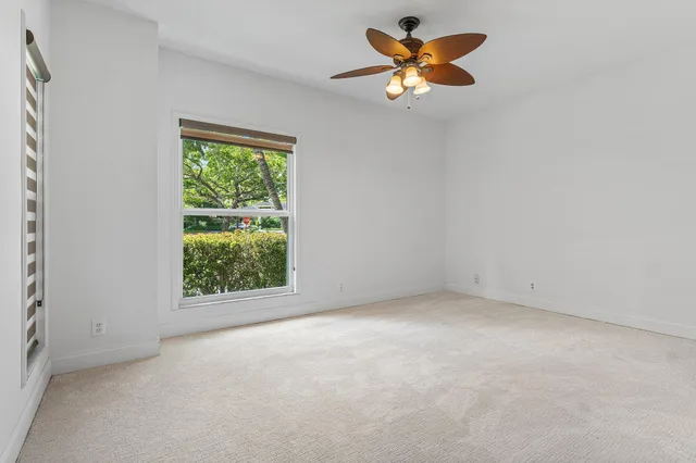 an empty room with a window and a fan
