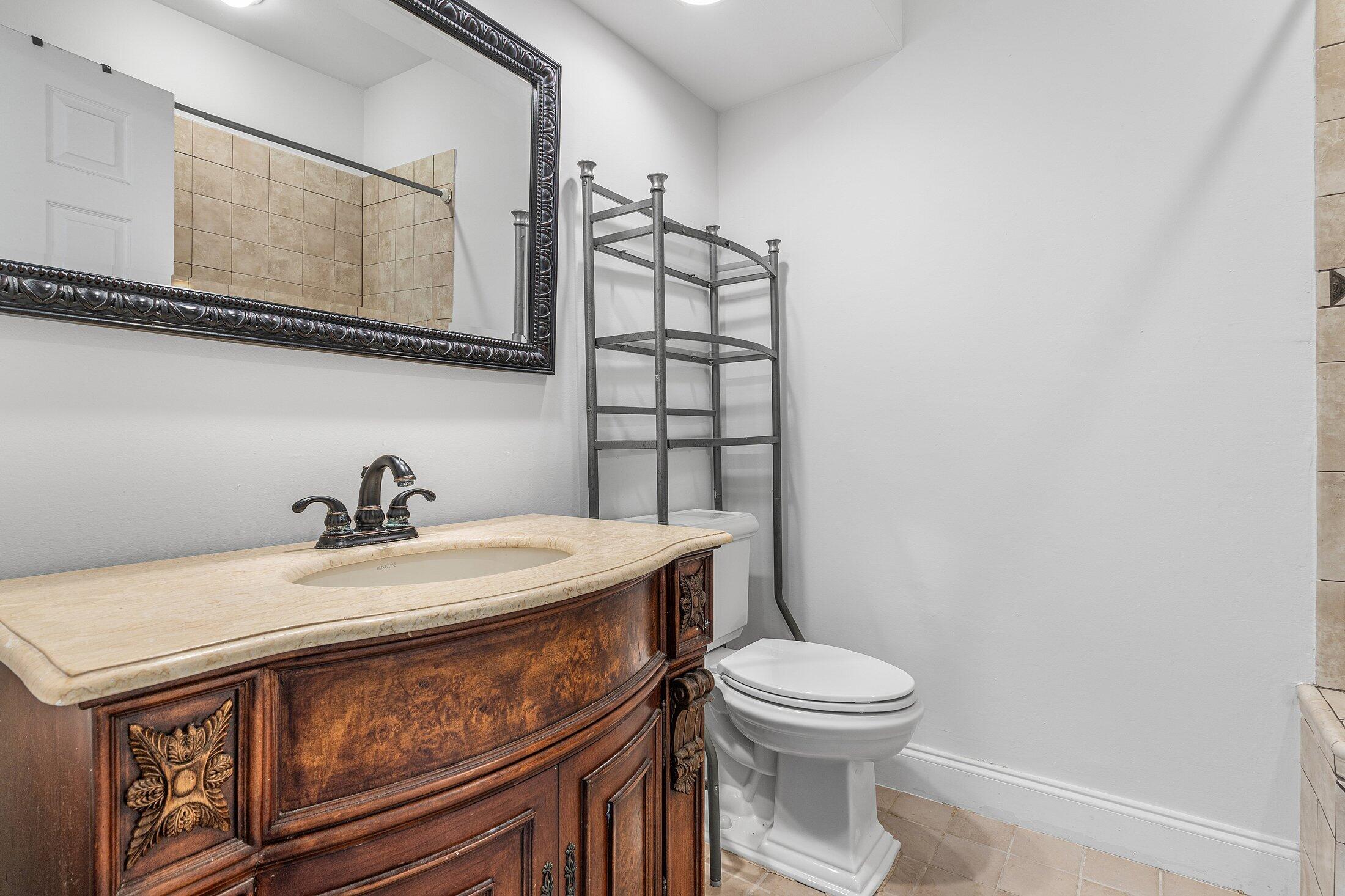 2599 Northwest 49th Street Boca Raton, FL 33434 - Photo 31 of 40 a bathroom with a sink a toilet and mirror