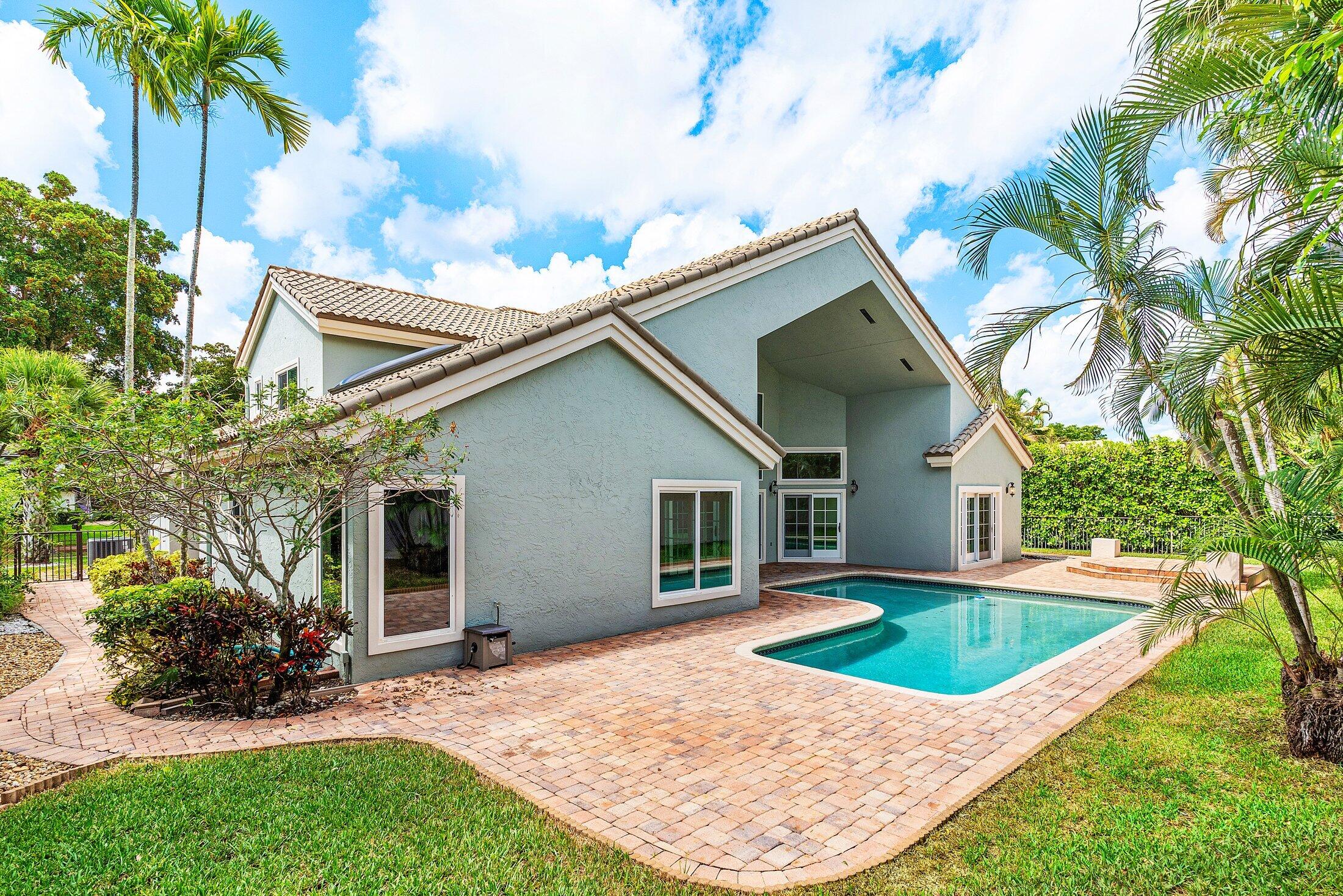 2599 Northwest 49th Street Boca Raton, FL 33434 - Photo 39 of 40 a view of a house with a yard and palm trees