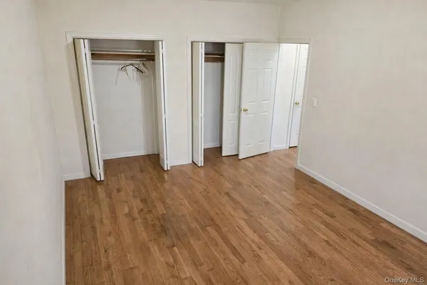 an empty room with wooden floor and closet