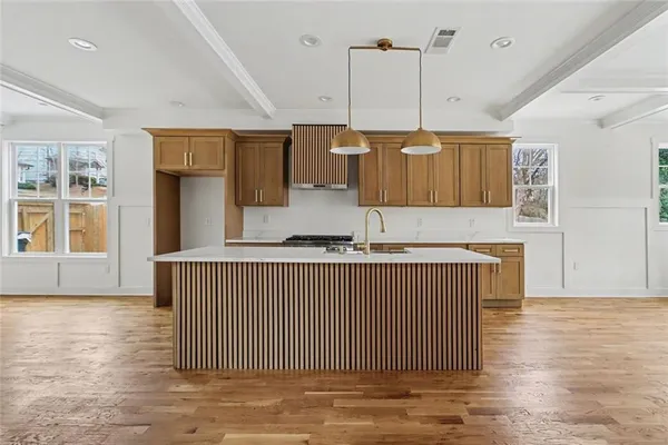 a kitchen with kitchen island granite countertop wooden cabinets a sink and a dishwasher