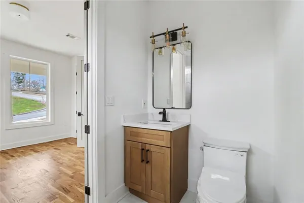 a bathroom with a toilet sink and mirror