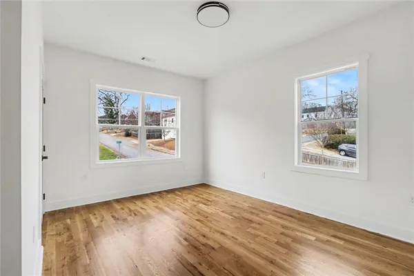 a view of an empty room with wooden floor
