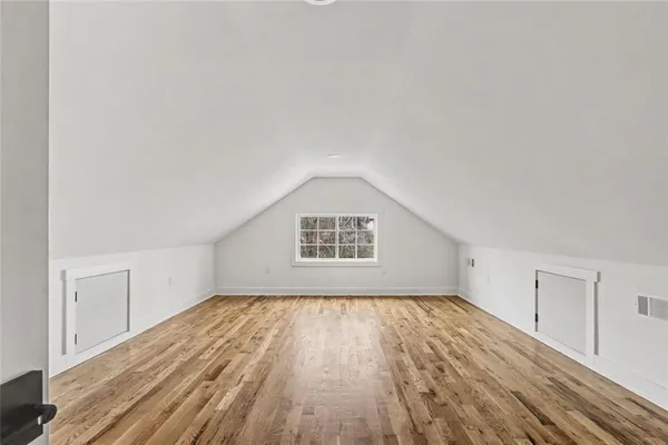 a view of a white house with a large space in front of it