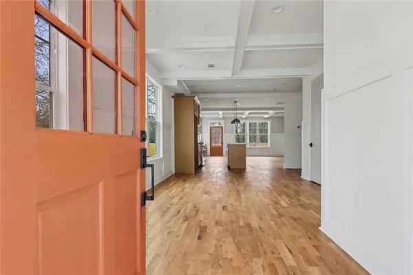 a view of a hallway with wooden floor and staircase