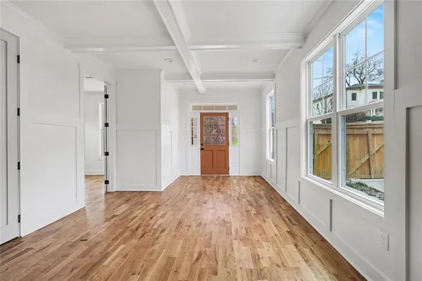 a view of a big room with wooden floor and windows