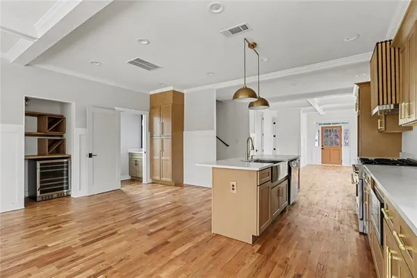 a kitchen with stainless steel appliances granite countertop a sink cabinets and wooden floor