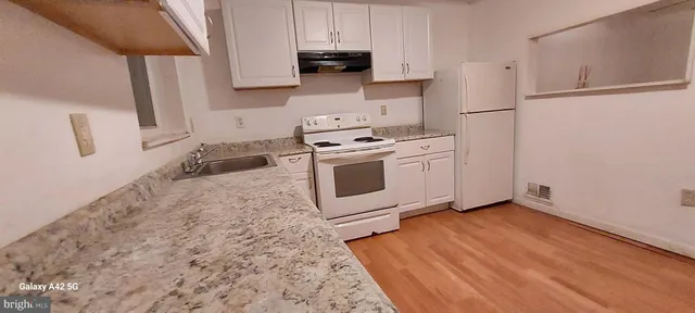 a view of a room with wooden floor