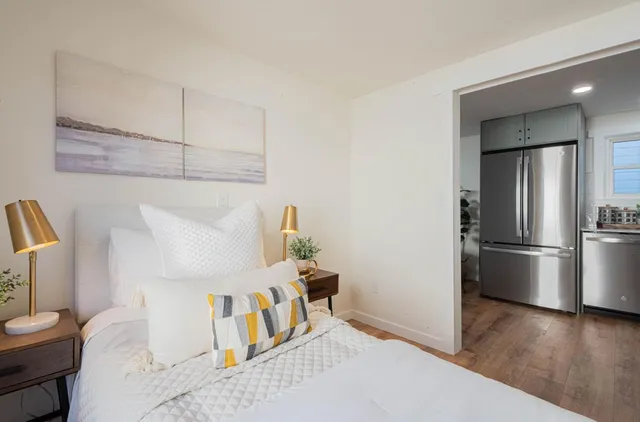 a bedroom with a bed and wooden floor