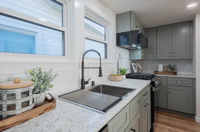 a kitchen with stainless steel appliances granite countertop a stove a sink and a microwave