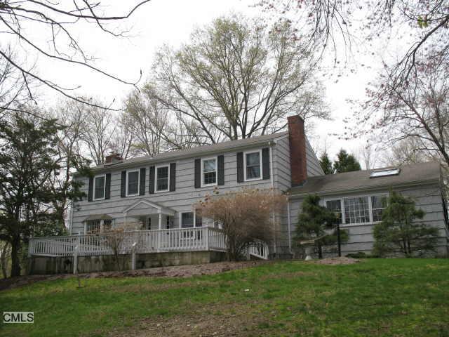 a front view of a house with a garden and trees