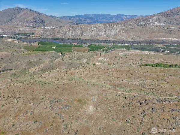 a view of a dry field with mountains in the background