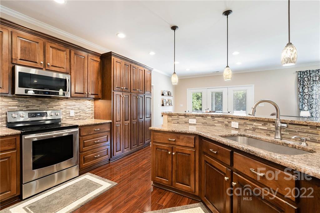 7920 Mt Olive Road Concord, NC 28025 - Photo 8 of 43 a kitchen with stainless steel appliances granite countertop a stove a sink and a microwave