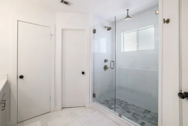 a spacious bedroom with two beds and painting on the wall