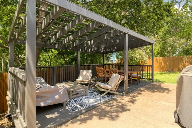 a balcony with wooden floor table and chairs