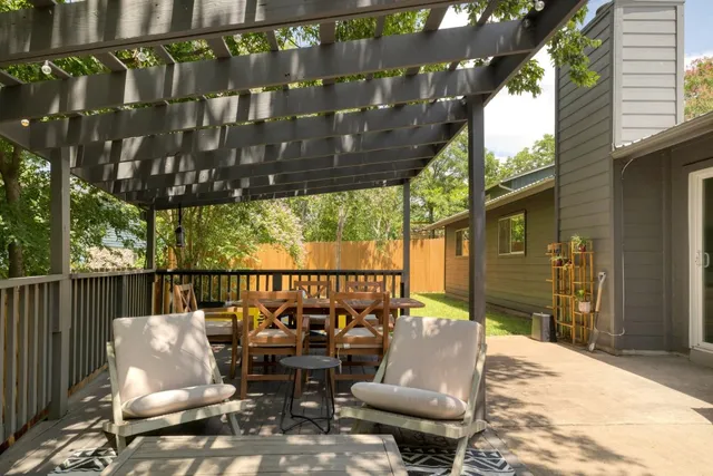 a view of swimming pool with table and chairs a wooden fence