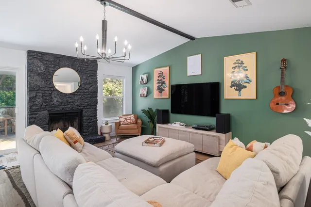 a living room with furniture a fireplace and a chandelier