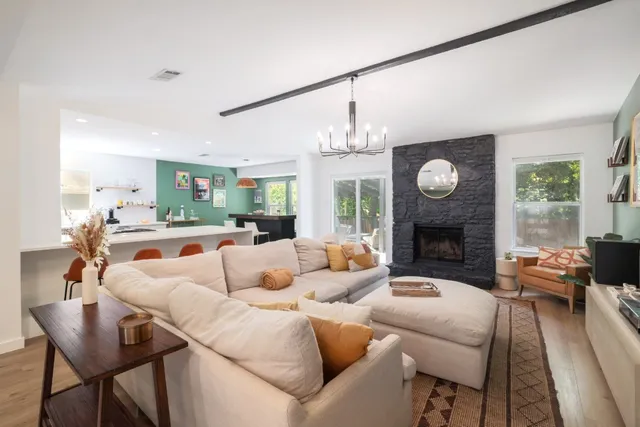 a living room with furniture a fireplace and a large window