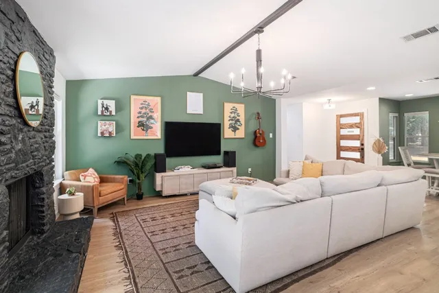 a living room with furniture a flat screen tv and a fireplace