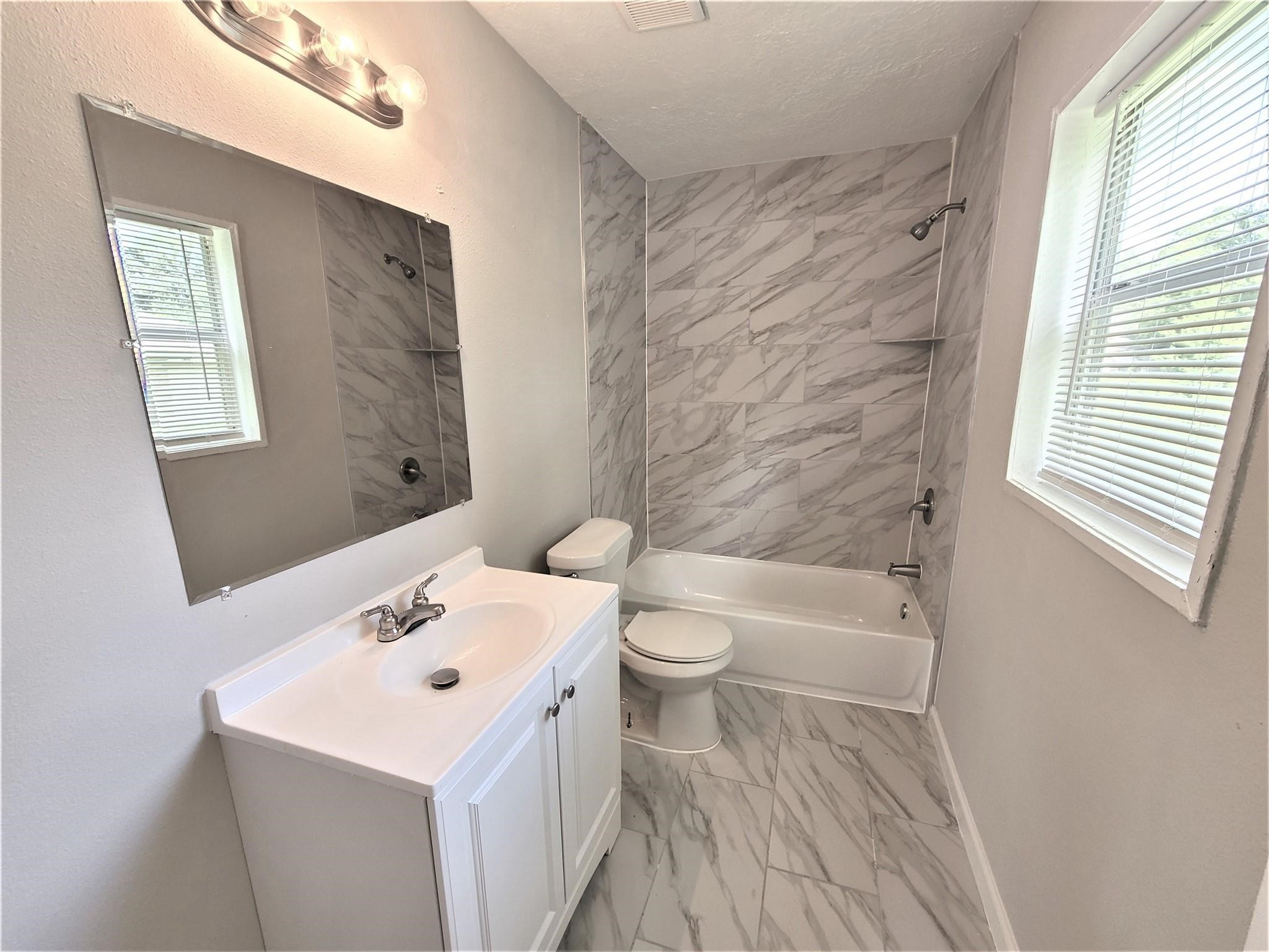 10329 Wicklowe Street Houston, TX 77016 - Photo 7 of 10 a bathroom with a sink a toilet and shower