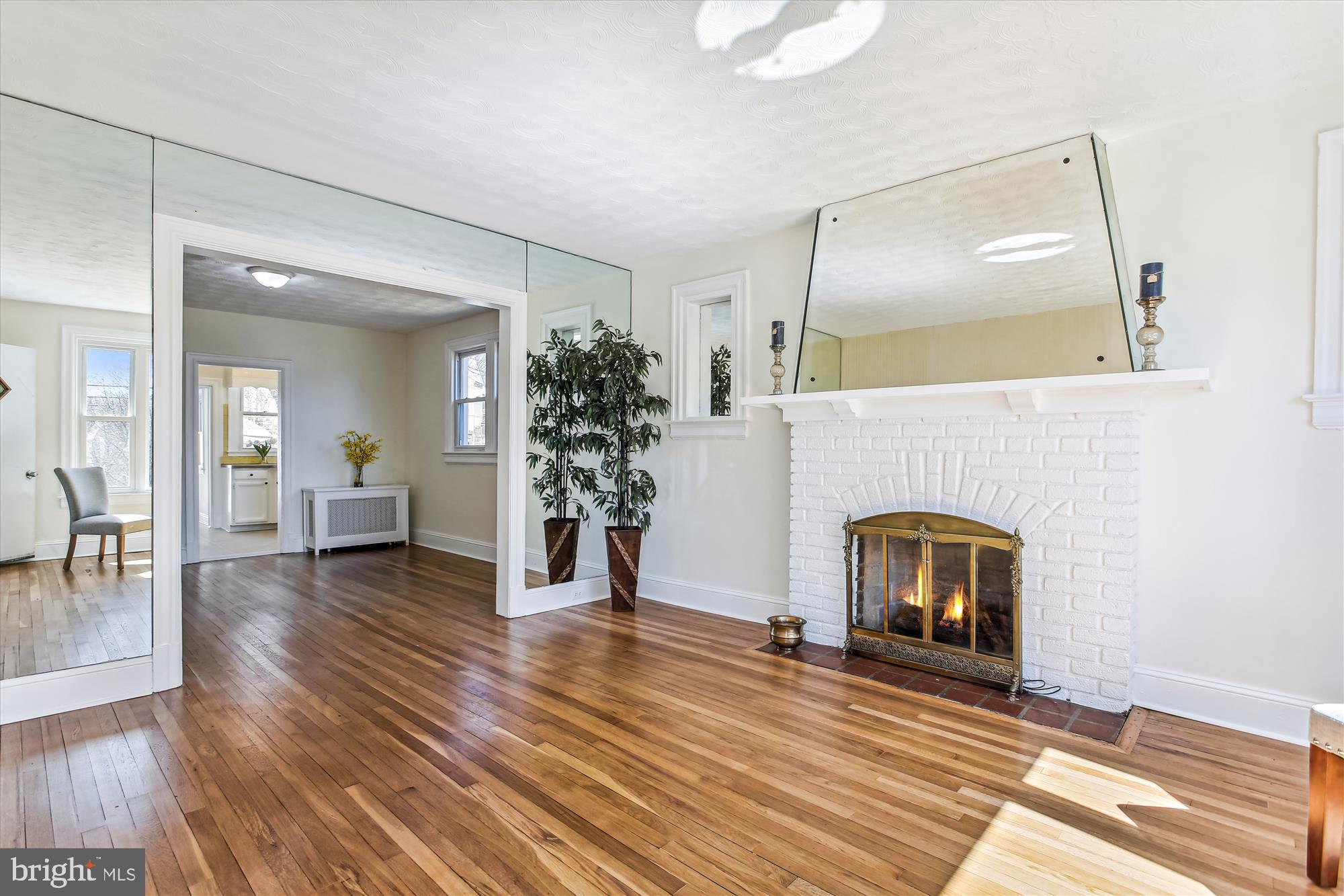 a view of empty room with fireplace and wooden floor