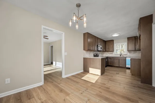 a large kitchen with a refrigerator and a stove top oven