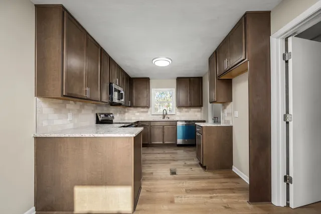 a kitchen with a sink a refrigerator and cabinets