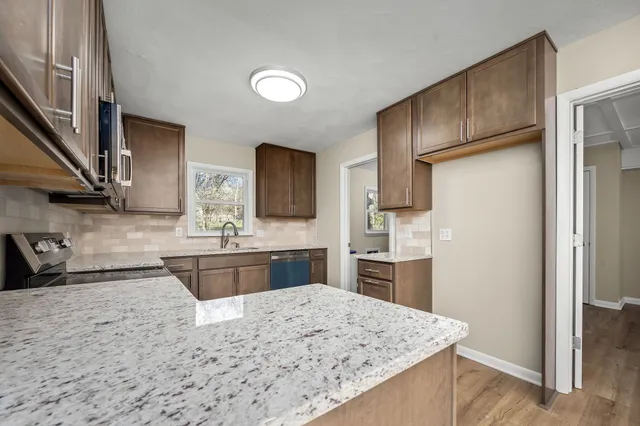 a kitchen with stainless steel appliances granite countertop a refrigerator stove microwave and sink