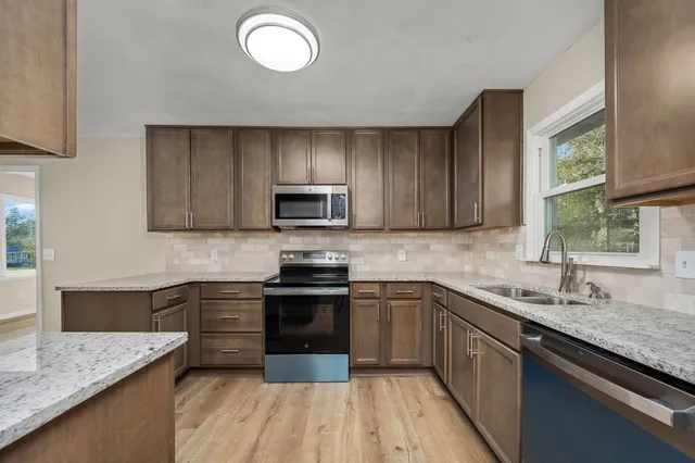 a kitchen with stainless steel appliances granite countertop a sink stove and microwave