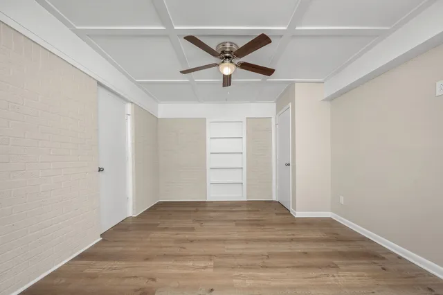 a view of a livingroom with a ceiling fan & wooden floor