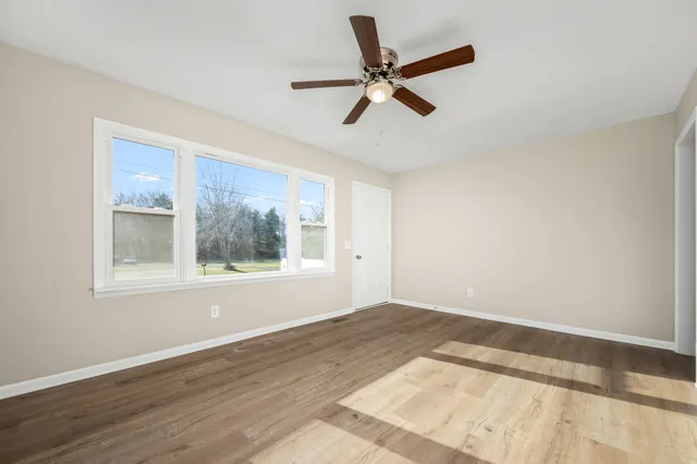a view of a big room with wooden floor and windows